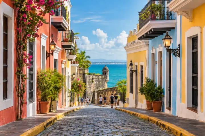 Calle colonial de San Juan con casas coloridas y vista al Caribe